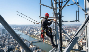 Construction worker wearing fall-arrest harness at height illustrating catastrophic fall risk in occupational insurance underwriting